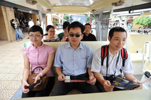 Tourist tramcars glide through Hanoi streets