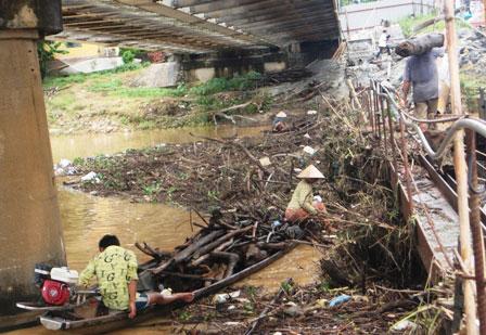 After the storm, fishing out wood on Huong River