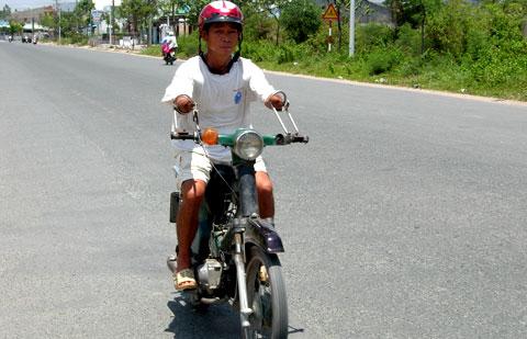 No-hand man carries his child to school by motorbike